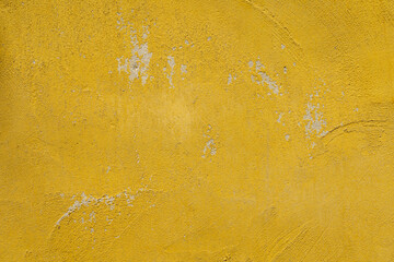 mustard yellow cement wall texture background has scratches and scuff marks.