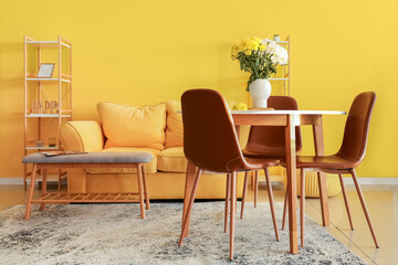 Vase with beautiful Chrysanthemum flowers on dining table in room