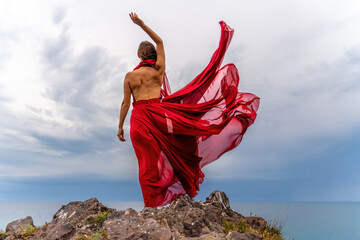 Woman in red dress dance over storm sky, gown fluttering fabric flying as splash