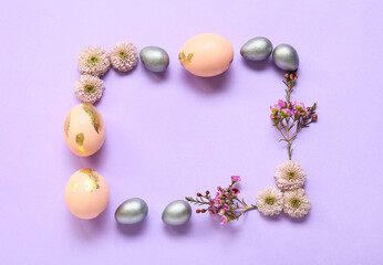 Frame made of Easter eggs and flowers on purple background