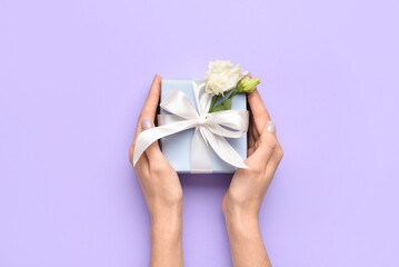Woman with gift box on color background