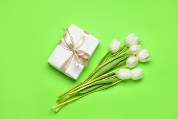 Gift box and tulip flowers on color background