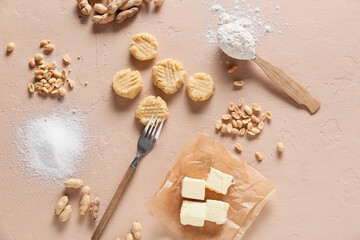 Uncooked peanut cookies and ingredients on beige background