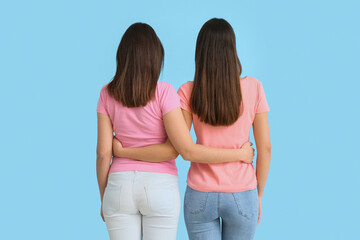 Beautiful hugging women on blue background
