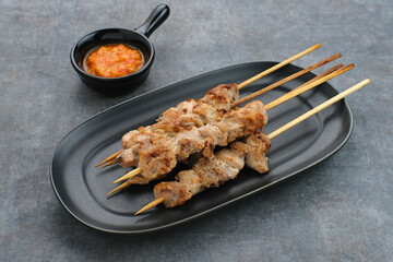 Sate Taichan, Grilled Chicken Satay without peanut sauce or soy sauce. Served on plate with sambal (chilli sauce). Selected focus.
