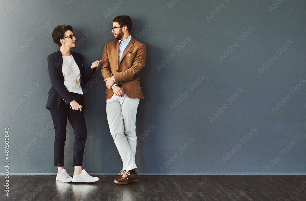 Poster You gain so much from mingling. Shot of two designers having a conversation while leaning against a wall.