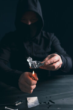 Drug addict man or drug dealer prepares heroin.