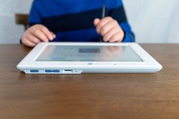 タブレット端末でする子供。タッチペン使用。コロナウイルス・小中学校の臨時休校