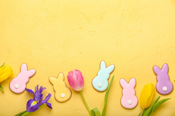 Tasty Easter cookies in shape on bunny and flowers on yellow background