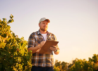 Ill be ready to harvest this crop soon. Shot of a happy farmer making notes on a clipboard while...