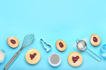 Delicious Easter cookies and utensils on blue background