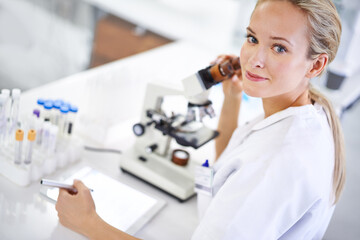 Recording her findings. Shot of a beautiful young scientist recording her findings on a tablet.