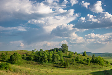 Obraz premium Thick clouds and green trees on the hills.