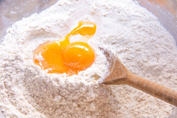 A pile of flour with an egg in the middle and a batch