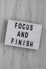 'Focus and Finish' on a lightbox on a white wooden background, top view. Flat lay, overhead, from above.