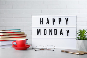 Light box with message Happy Monday, office stationery and cup of coffee on desk