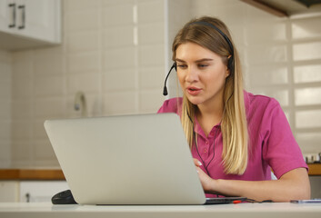 It support operator in headset speaking on web camera in laptop computer. Call center specialist...