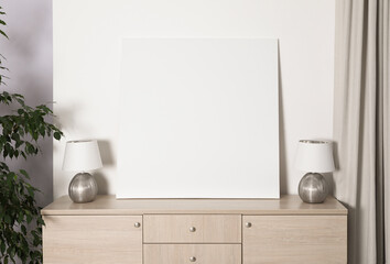 Blank canvas on wooden cabinet indoors. Space for design