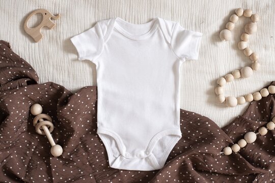 Studio photo of white bodysuit on neutral brown boho napkin for nursery sublimation design presentation