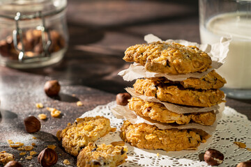 Homemade cookies with chocolate, nuts and milk on a wooden table and art background in the morning. Close. Breakfast.