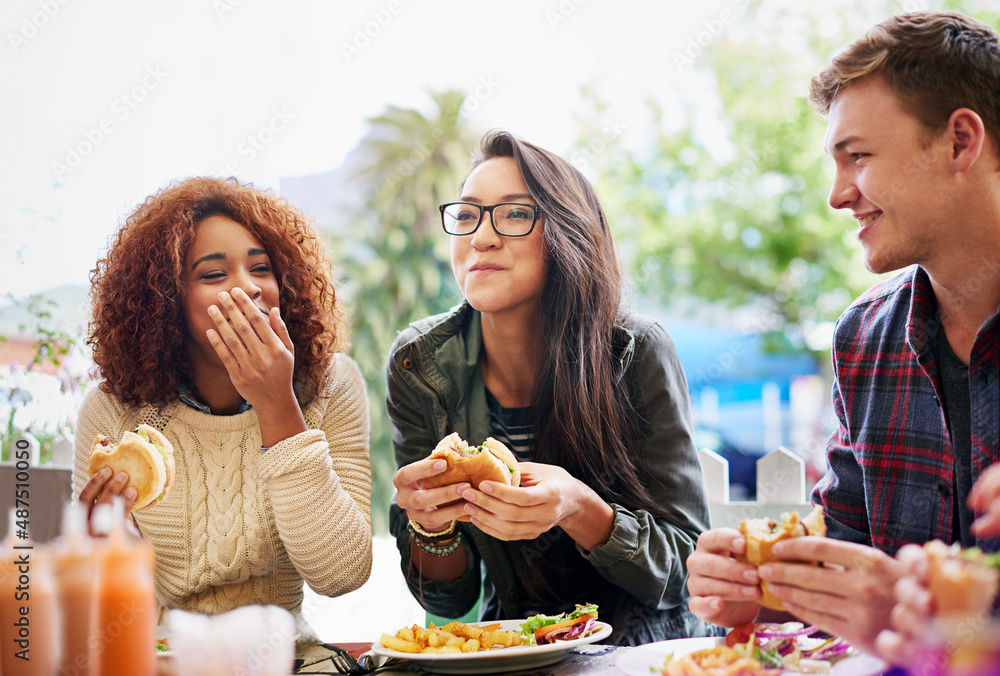 Poster Good food and laughter go hand-in-hand. Cropped shot of three friends eating burgers outdoors.