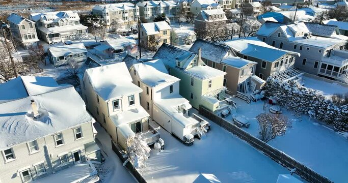 Backyard view covered in winter snow. Residential neighborhood in USA during sunny Christmas day. Aerial.