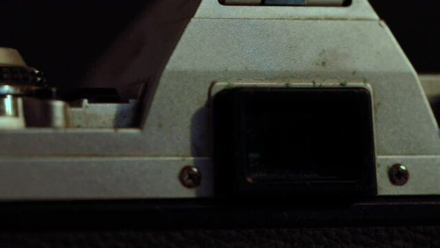 Close up, vintage camera finder rotating in dark room with soft lighting