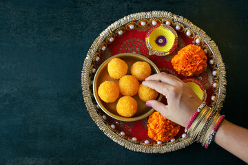 Diwali sweets coconut petha ladoo Motichoor Laddu woman hand serving Indian sweet festival mithai...