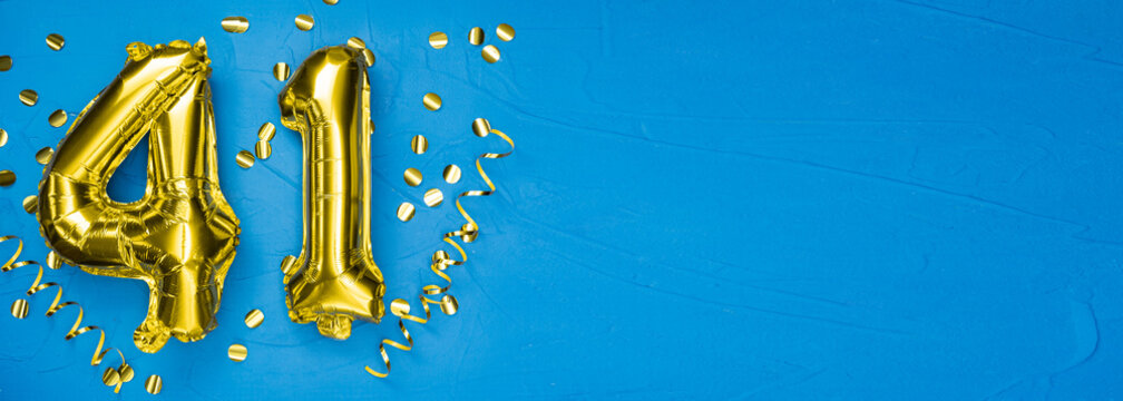 gold foil balloon number forty one. Birthday or anniversary card with 41 inscription. blue concrete background. Anniversary celebration. Banner.