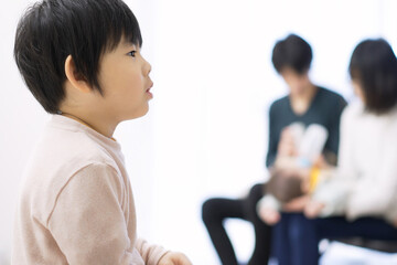 赤ちゃんの授乳中に大人しくテレビを見る幼児