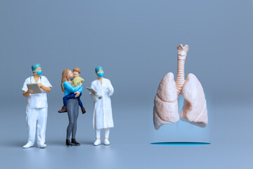 Miniature Doctors study and treat large human lungs, World Health Day concept.