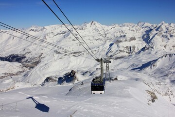 Fototapeta na wymiar Shadow of the Cable Car on the Snow, Travelling Up to Le Grande Motte Ski Field, Tignes, France