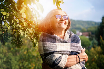 Beautiful mature senior happy smiling woman in spring garden of her country house