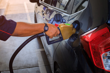 Pumping gas at gas pump. Closeup of man pumping gasoline fuel in car at gas station.