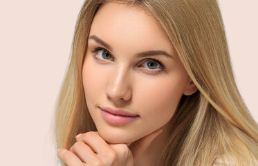 Long smooth blonde hairstyle beauty woman close up portrait touching her face Color background pink