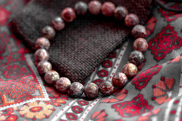 a bracelet or beads made of natural leopard jasper lie on the ethnic surface