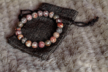 a bracelet or beads made of natural leopard jasper lie on the ethnic surface