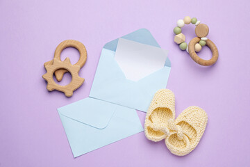 Envelopes for baby shower and accessories on lilac background, flat lay