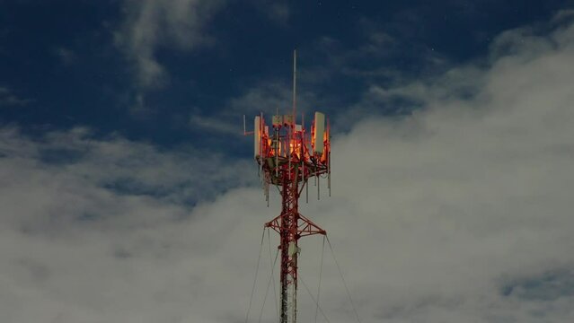 Timelapse of antenna through clouds at nigh with stars sky