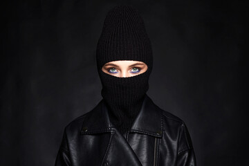 Fashionable girl in black balaclava and leather coat
