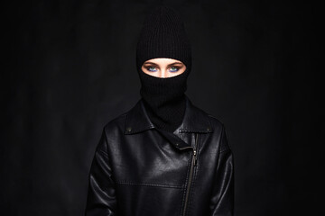 Fototapeta na wymiar Fashionable girl in black balaclava and leather coat