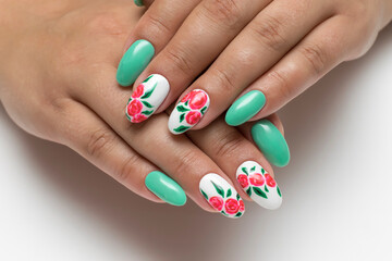 Mint white manicure on long oval nails with painted red flowers on a white background close-up