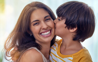 Theres something extra special about the mother son connection. Shot of an adorable little boy affectionately kissing his mother at home.
