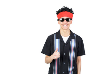Happy guy doing thumb up smiling looking at camera. Wearing an afro wig and sunglasses. Retro 90s style. Isolated on white background. Latin 18-20 years old guy.