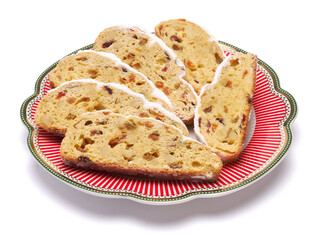 Slices of Traditional Christmas stollen cake with marzipan and dried fruit isolated on ceramic plate