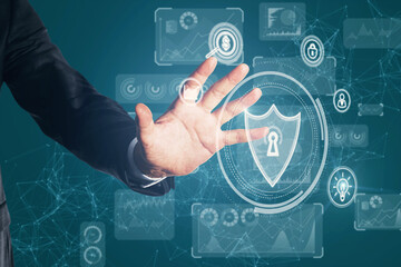 Businessman hand using creative glowing protection shield with polygonal mesh connections and business icons. Safety, security and communication concept.