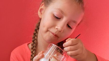 Child eating yogurt jelly pink background. Dairy product diet Lactobacillus Acidophilus, healthy homemade breakfast menu. Kids healthcare. Vegan food nut milk gelatin non-dairy dessert Protein pudding