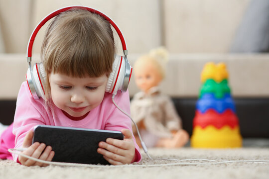 Little girl kid watching cartoon on smartphone device, digital entertainment for child