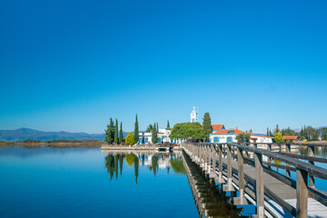 Architecture. View from the bridge to the beautiful monastery of st. Nicholas, built on lake vistonida, port of lagos, xanthi region in northern greece. Magnificent landscape of a european country