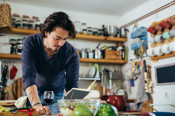man reading cook book in kitchen . preparing a meal